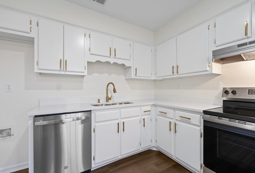 Fresh white cabinetry paired with updated countertops, stainless steel dishwasher, and modern fixtures create a clean and timeless design.