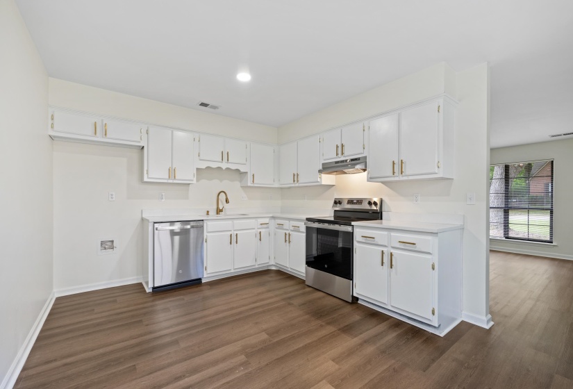 Beautifully updated kitchen featuring white cabinetry, granite countertops, stainless steel appliances, and modern hardware.