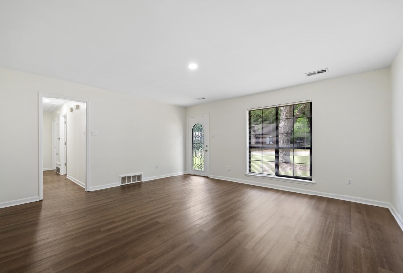 Wide-open great room showcasing the home's spacious layout, updated flooring, fresh paint, and endless possibilities for furniture placement.