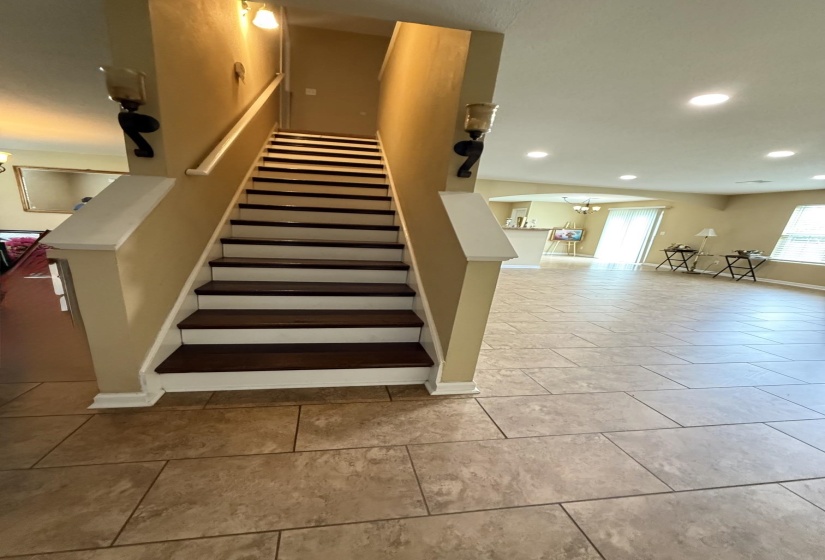 Staircase featuring dark wood-finish treads, white risers, and a light-toned handrail