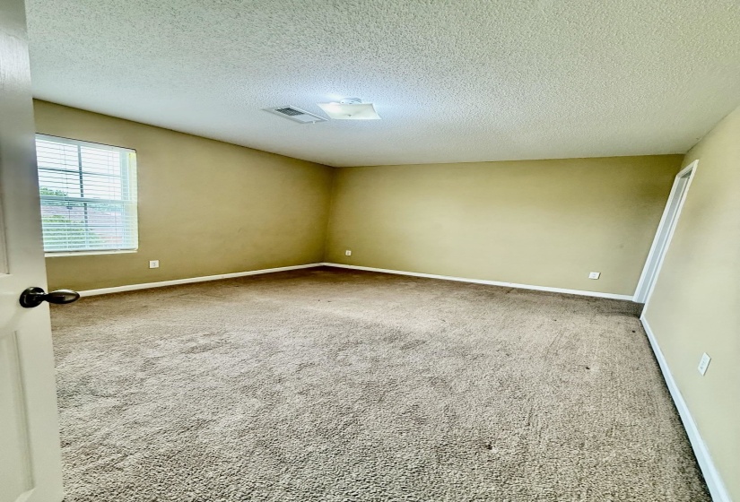 Carpeted room featuring a window with blinds, overhead lighting, baseboard trim, and a textured ceiling