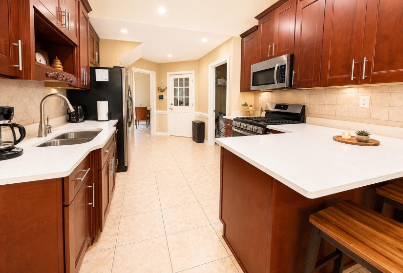Kitchen featuring cherry-toned cabinetry and white countertops