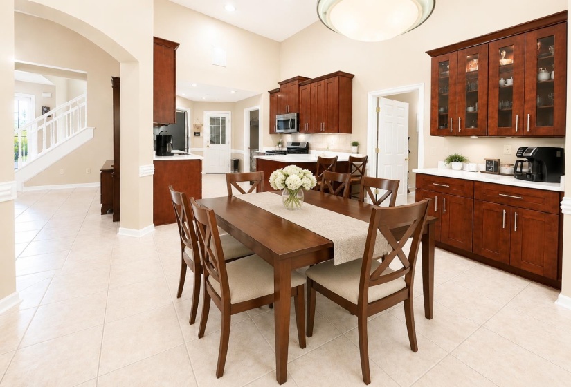 Kitchen and dining area featuring rich wood cabinetry, light countertops, and tile flooring