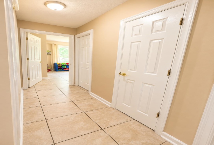Hallway featuring light-toned tile flooring and neutral wall paint