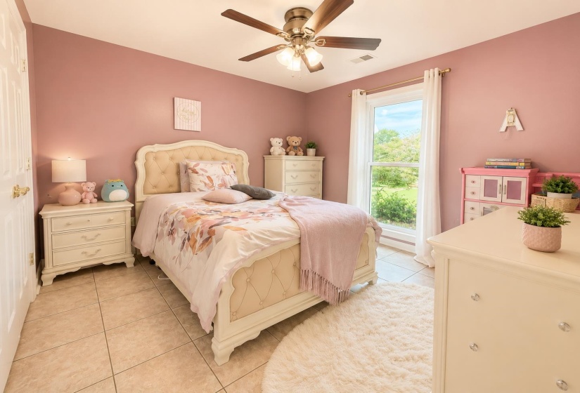 Spacious room with a large window, tile flooring, and a ceiling fan with integrated lighting