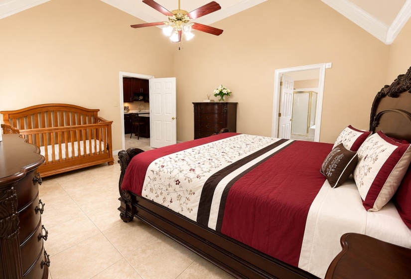 Spacious room with a vaulted ceiling, crown molding, and a ceiling fan with integrated lighting