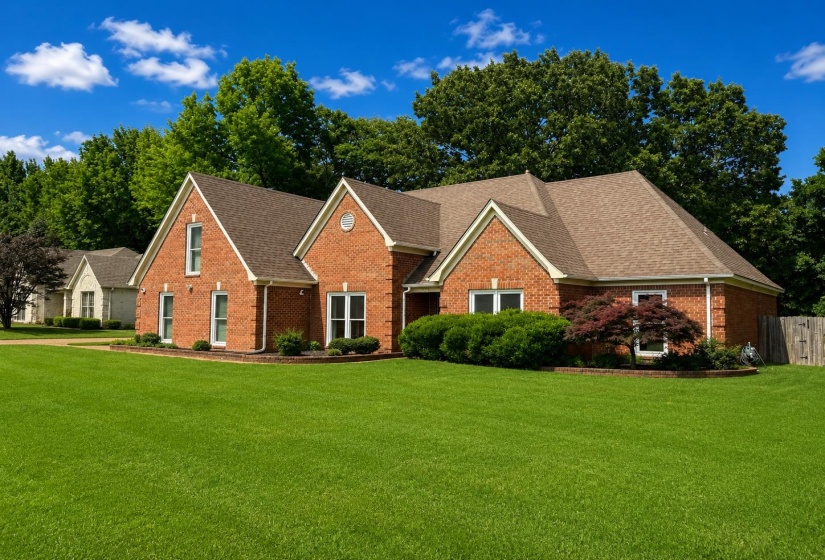 Traditional brick residence featuring a prominent gabled roofline and white-trimmed windows