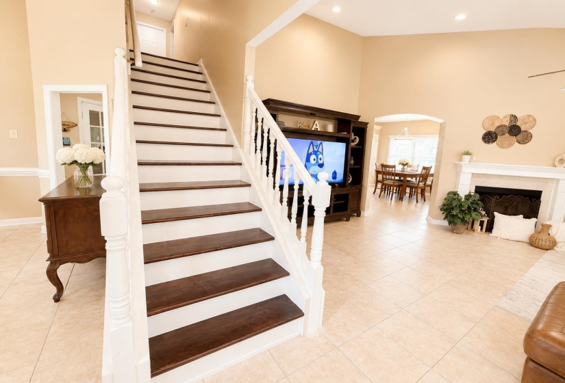 Two-story foyer featuring a wood-finish staircase with white risers and balusters