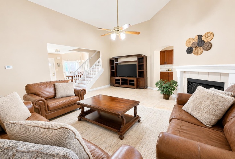 Spacious living area featuring a vaulted ceiling and ceiling fan