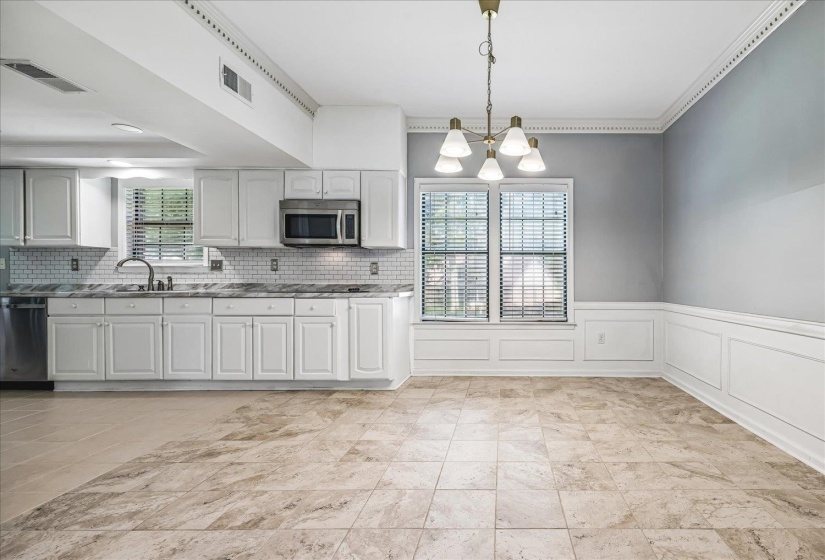 Open-concept kitchen and dining area featuring light-toned tile flooring