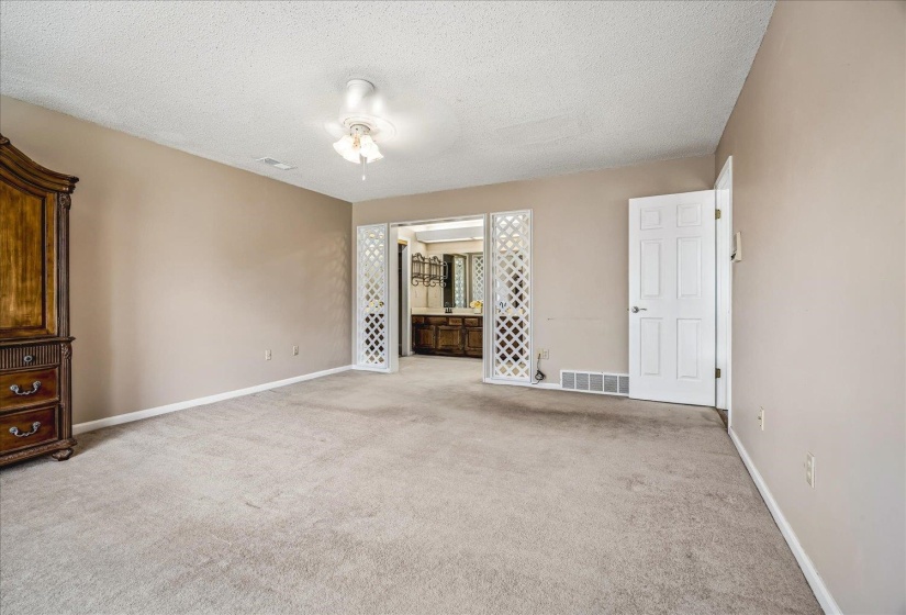 Spacious room featuring neutral carpeting and wall tones