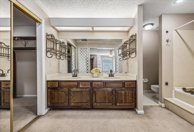 Dual vanity with wood-finish cabinetry, light-toned countertop, and undermount sinks