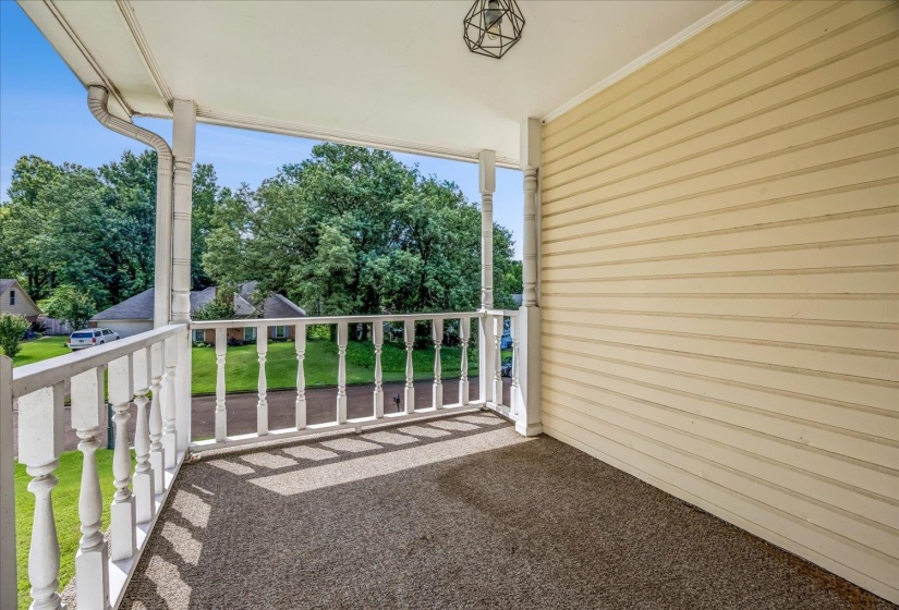Covered porch featuring a textured surface, white spindle railing, and a geometric pendant light fixture
