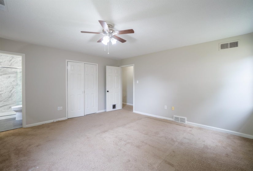 Carpeted room with a ceiling fan light fixture
