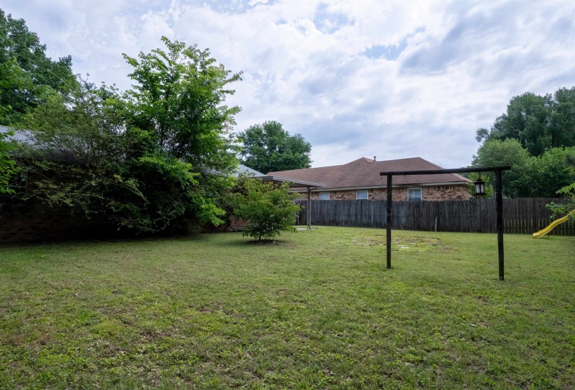 Expansive green lawn with mature perimeter trees and shrubs