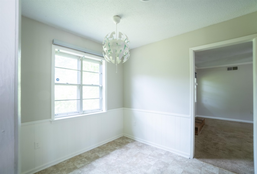 Interior space featuring wainscoting, an overhead light fixture, and window with natural light