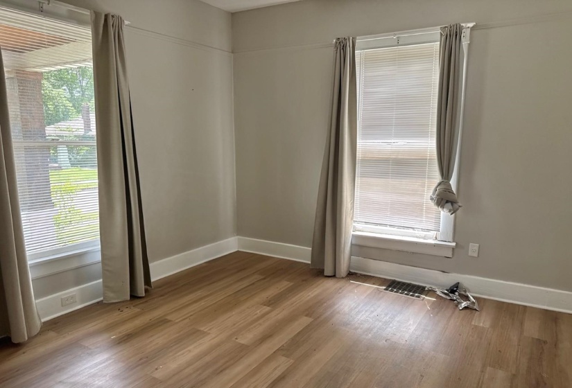 Room featuring wood-finish flooring, light-toned wall paint, and white trim molding