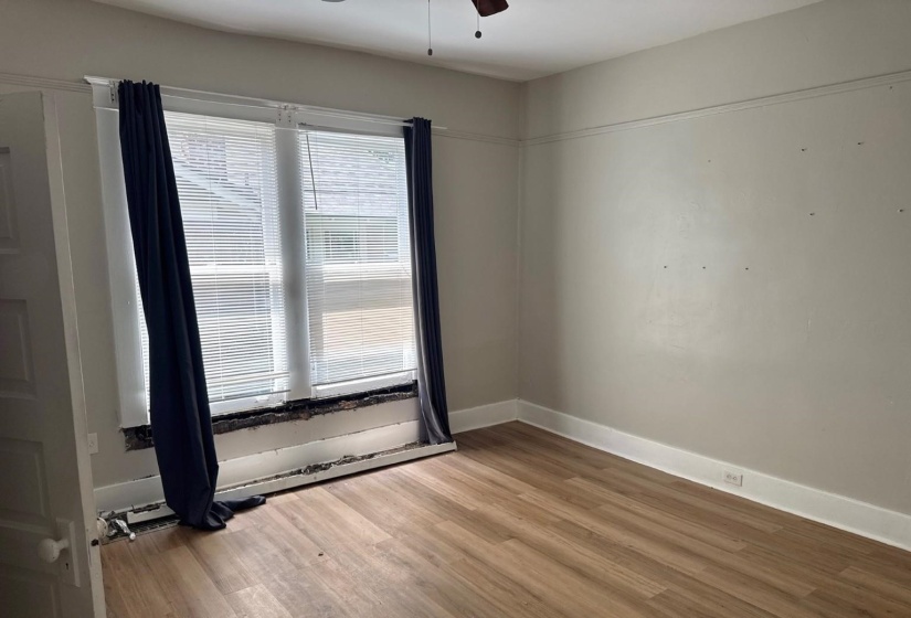 Spacious room featuring wood-finish flooring and a ceiling fan
