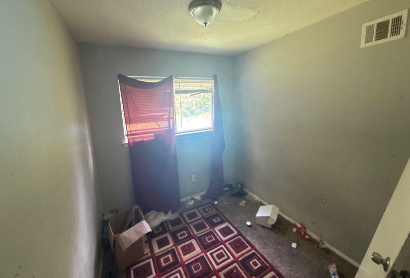 Room with light gray walls, a single window, and a ceiling-mounted light fixture