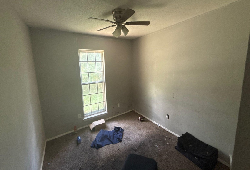 Room featuring a ceiling fan with integrated lighting and a window with white trim