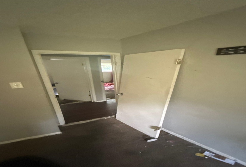 Interior hallway with light gray walls and dark flooring