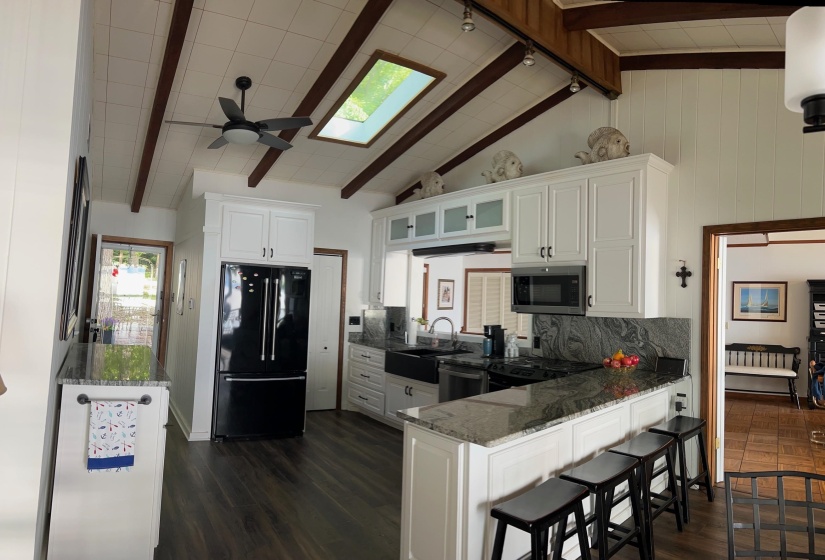 Vaulted ceiling with exposed wood beams and skylight