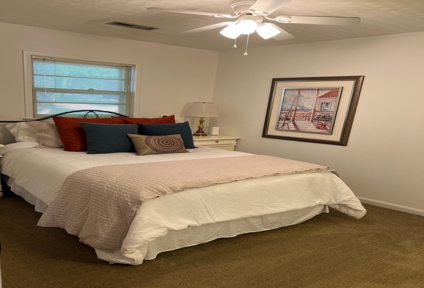 Bedroom featuring neutral wall paint, a ceiling fan with light fixture, carpeted flooring, and a single window with blinds
