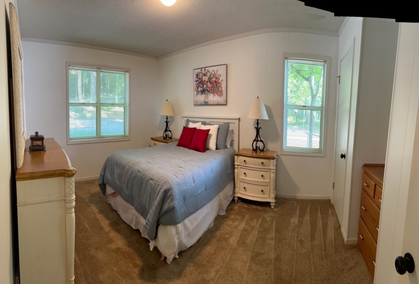Carpeted room with white walls, two double-hung windows, and a white paneled door