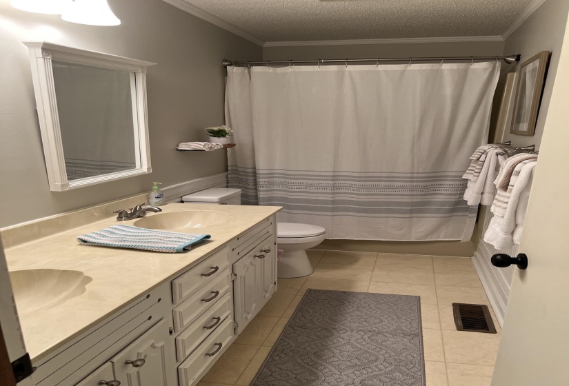 Dual vanity with integrated sinks and white cabinetry, featuring a matching framed mirror