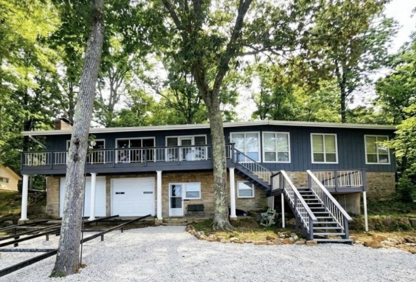 Two-story residence featuring a stone and siding exterior