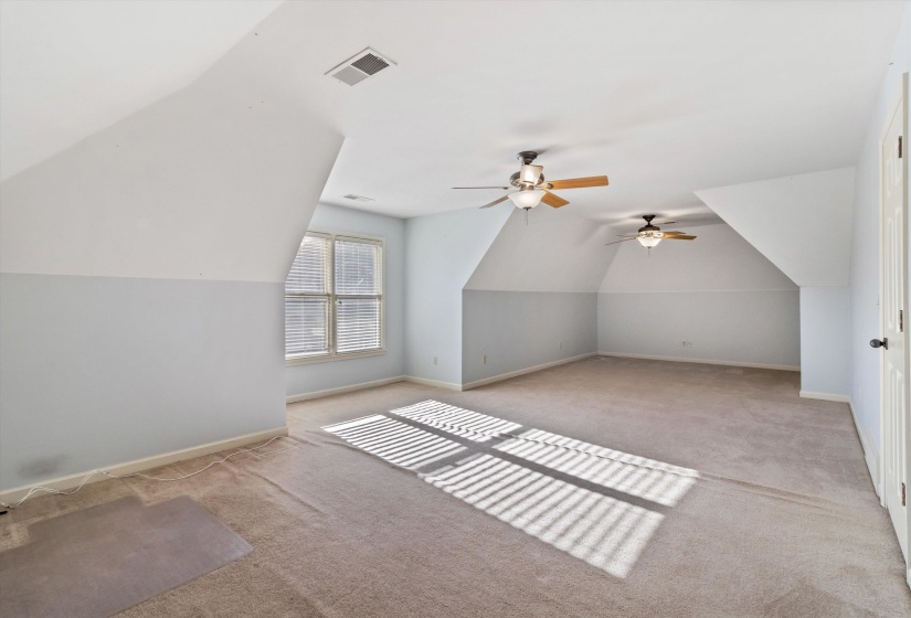 Bonus room with ceiling fan, vaulted ceiling, and light colored carpet