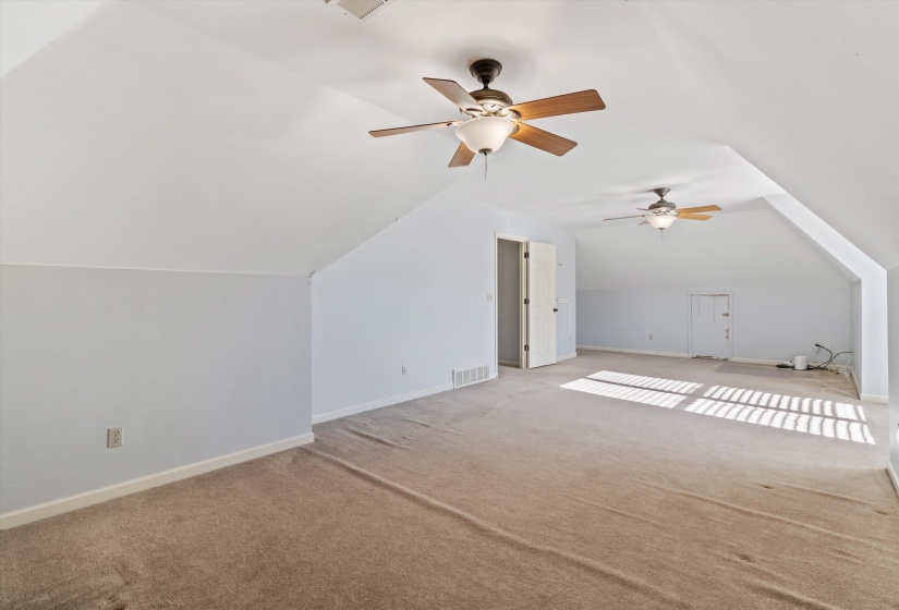 Bonus room featuring carpet flooring, vaulted ceiling, and ceiling fan