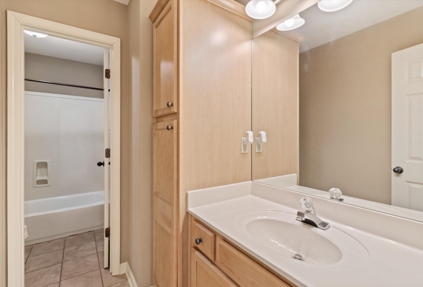Bathroom featuring vanity, light tile patterned flooring, and shower / bathtub combination