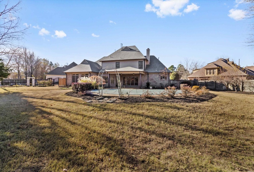 Back of property featuring a chimney, a patio, a fenced backyard, and brick siding