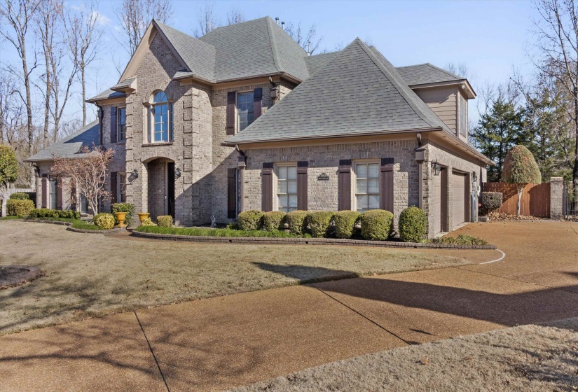French country style house featuring roof with shingles, brick siding, and an attached garage