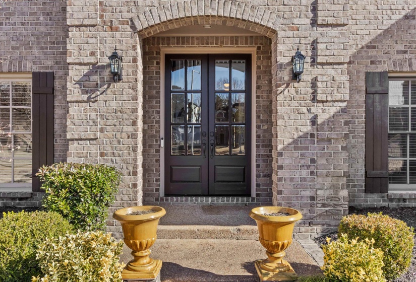 Property entrance featuring brick siding and french doors
