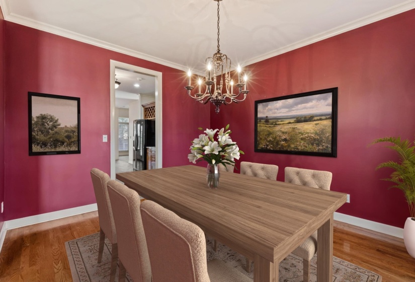 Dining space with light wood-style floors, a chandelier, and ornamental molding