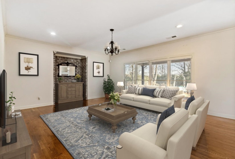 Living area with wood finished floors, a chandelier, recessed lighting, and crown molding