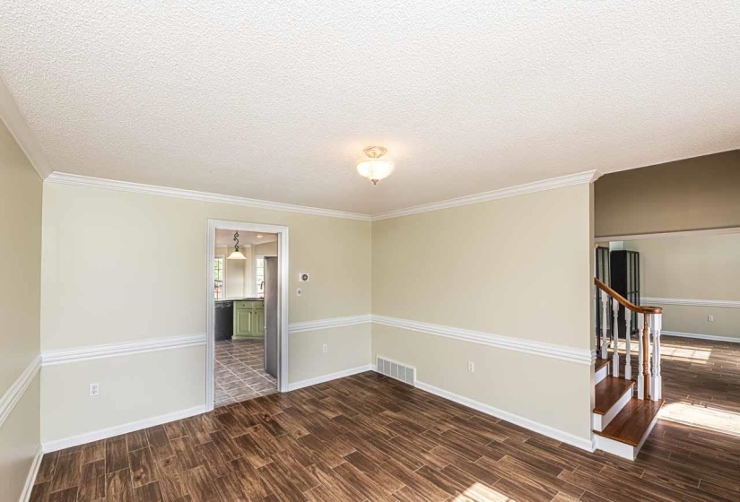 Spare room featuring wood tiled floors, a textured ceiling, and crown molding