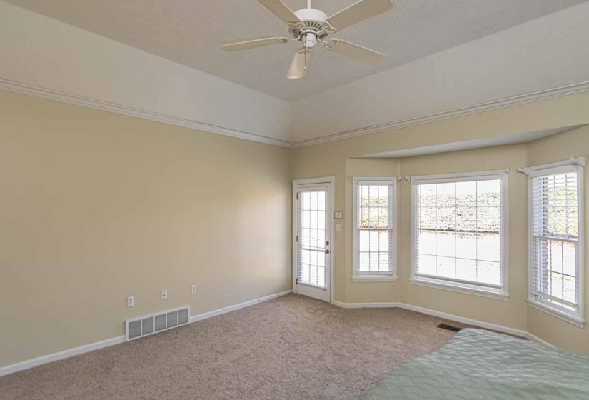 Unfurnished bedroom with carpet, a ceiling fan, and ornamental molding
