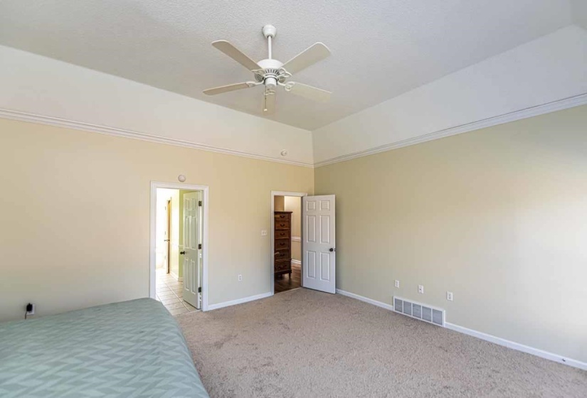 Unfurnished bedroom featuring light colored carpet, a ceiling fan, and lofted ceiling