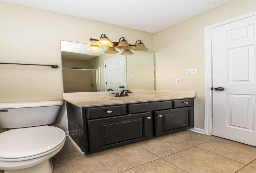 Full bathroom with a stall shower, vanity, and light tile patterned floors