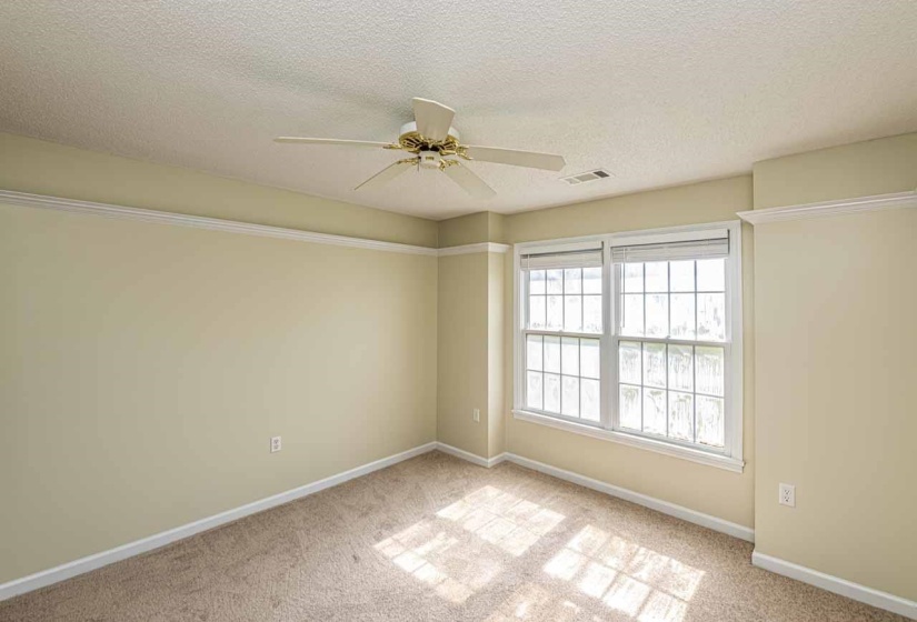 Unfurnished room with a textured ceiling, a ceiling fan, and light colored carpet