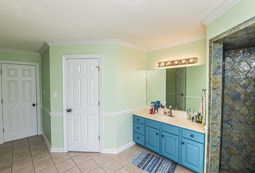 Bathroom with vanity, a textured ceiling, crown molding, light tile patterned floors, and a shower with curtain