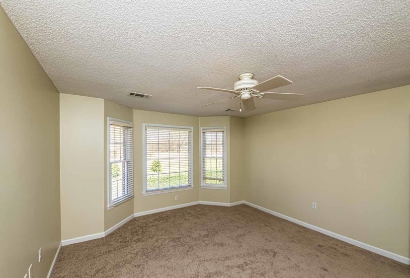 Spare room featuring ceiling fan, light colored carpet, and a textured ceiling