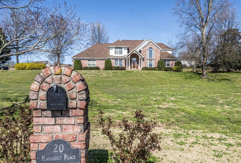 Traditional-style home featuring a front yard and brick siding
