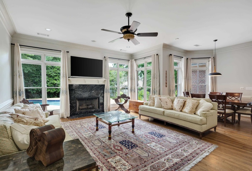Living area with wood-finish flooring, recessed lighting, and crown molding