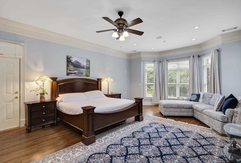 Spacious room with wood-finish flooring, a bay window with multiple panes, recessed lighting, and a ceiling fan