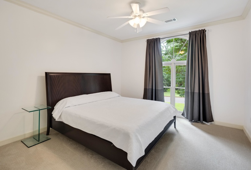 Arch-top window with mullions, crown molding, and a ceiling fan with integrated lighting