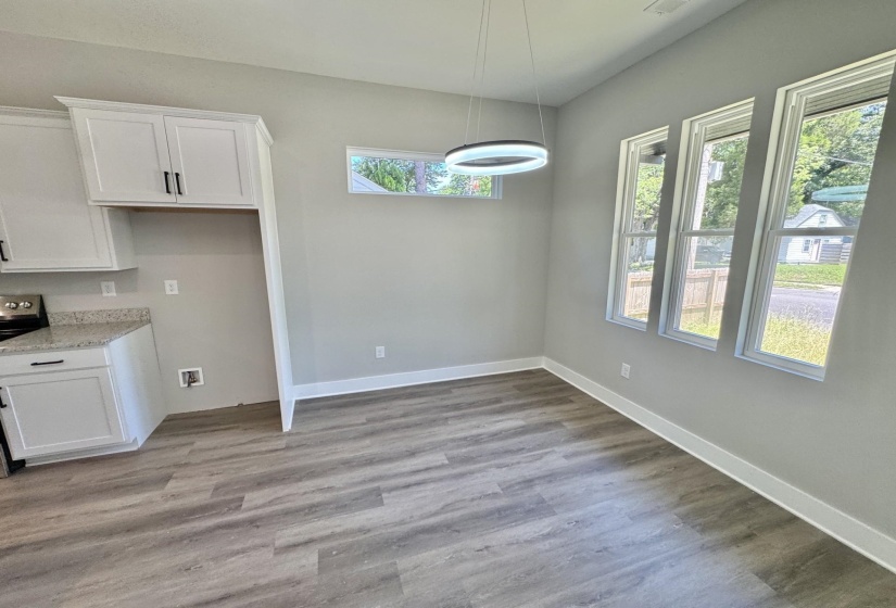 Open-concept room featuring wood-finish flooring, white baseboards, and light gray walls